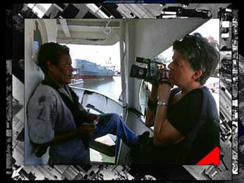 Barbara Jo Revelle interviews the captain of the Haitian trading vessel God Is Able, still frame from  Imaging the Miami River, 1998.