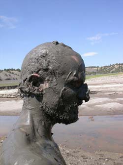 Blake Gibson in the mud, El Vado Lake, New Mexico, 2002, photograph by Chris Taylor
